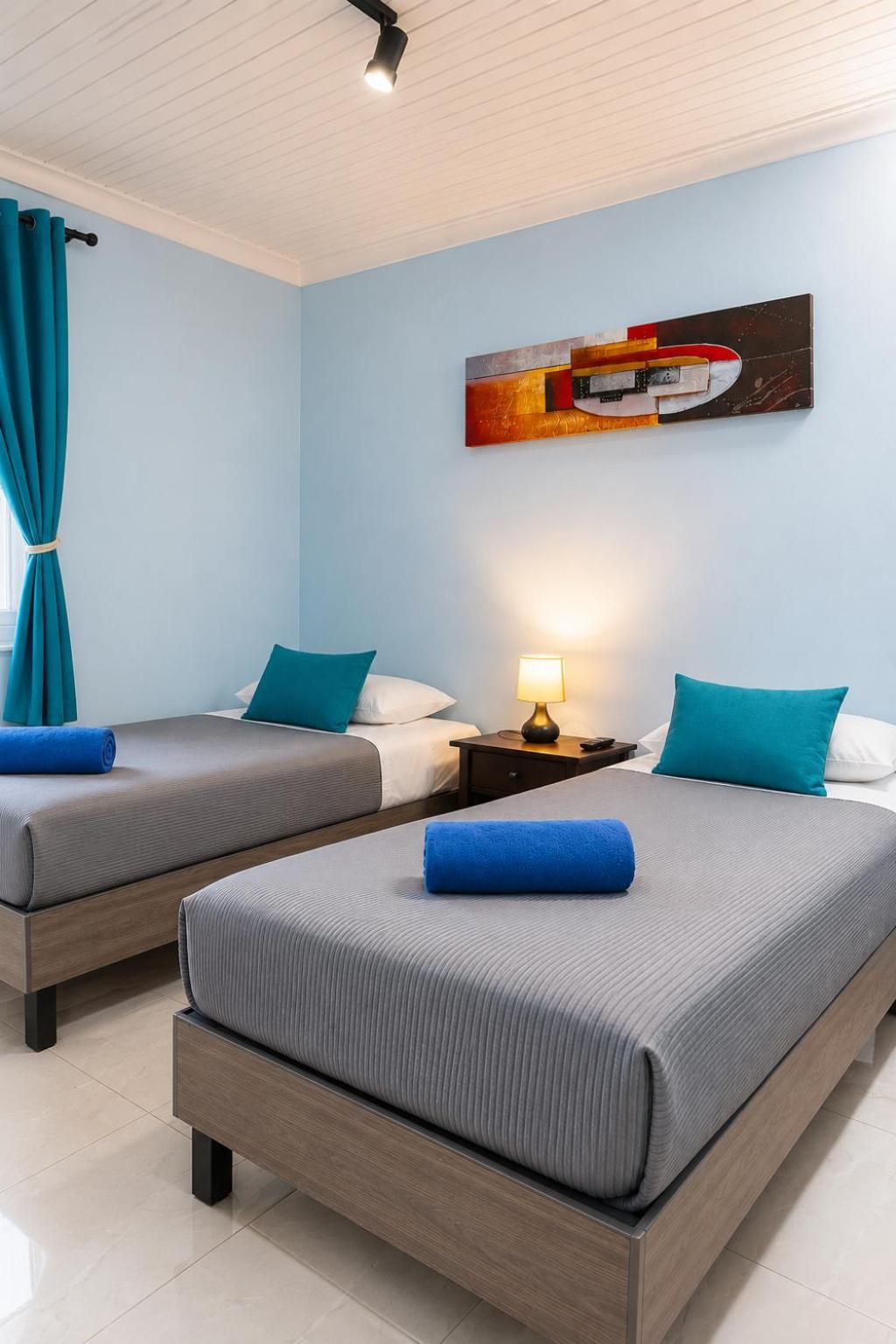 Quarto com 2 Camas de Solteiro e Banheiro Compartilhado
